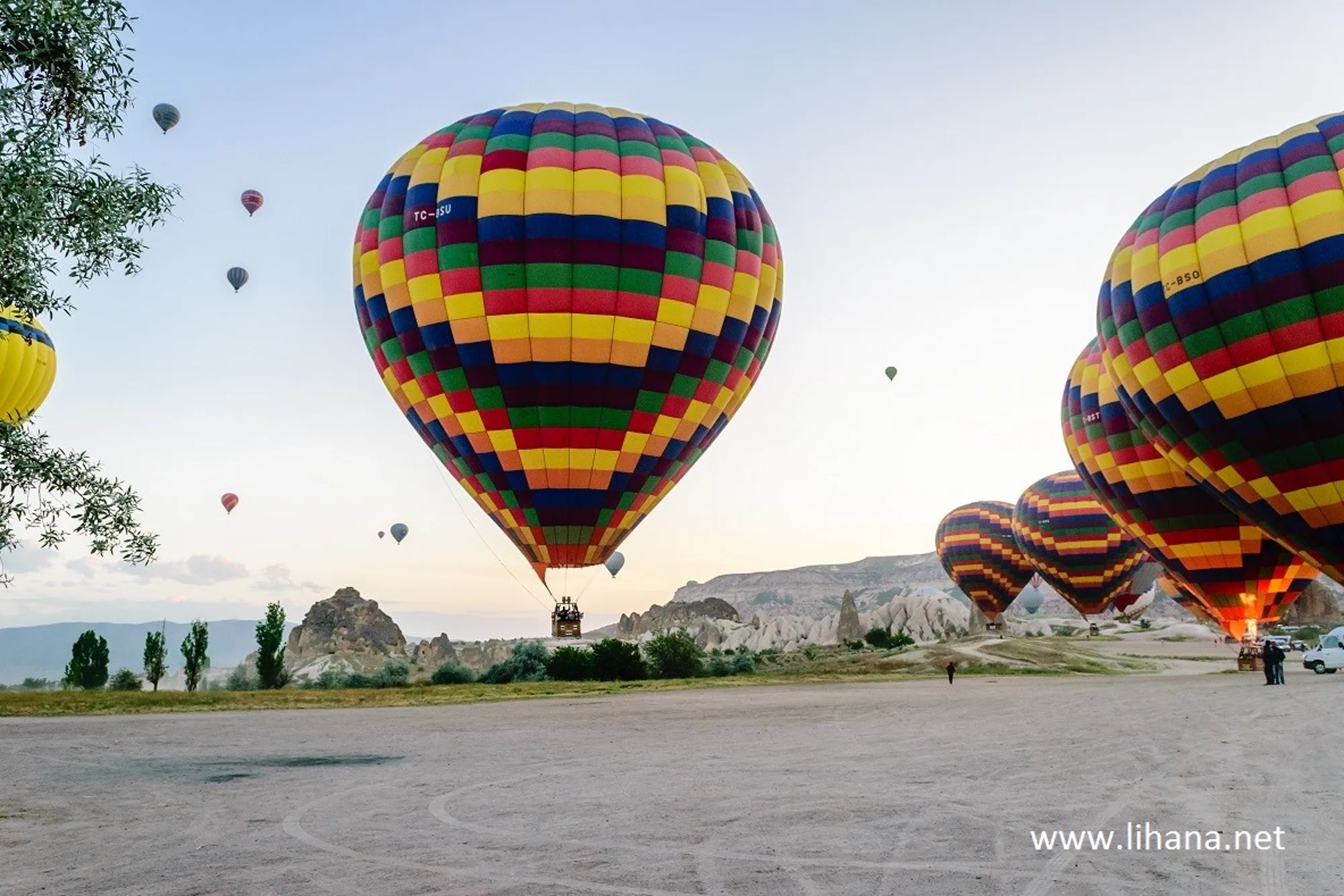 Разноцветный воздушный шар только что приземлился, рядом туристы